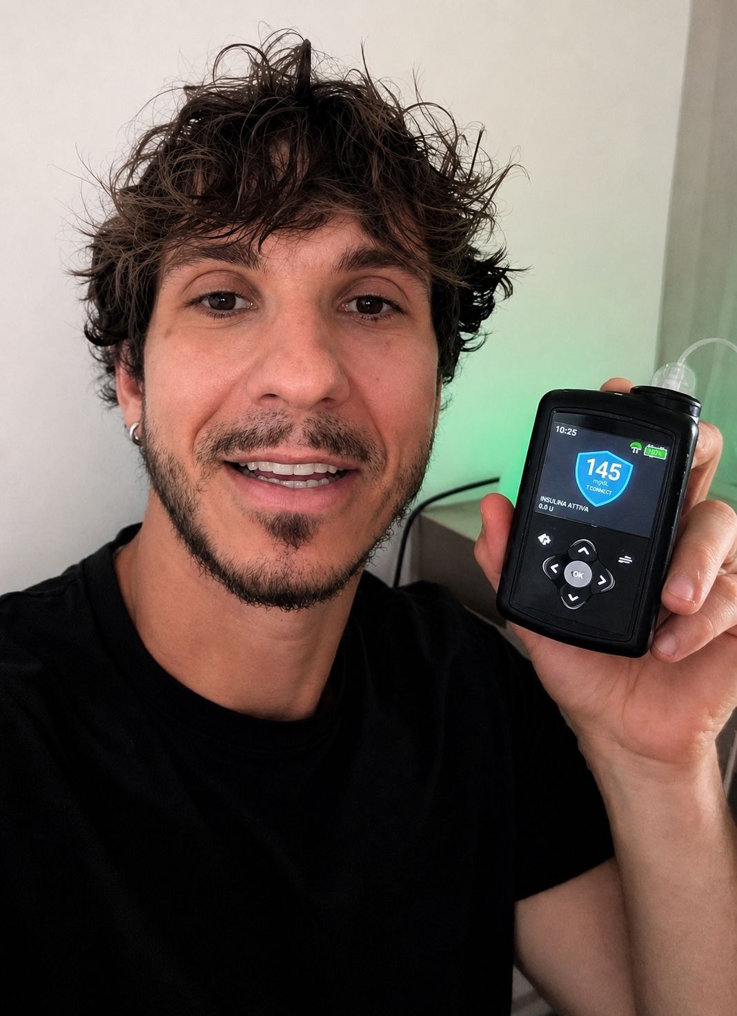 Fabio sorride mostrando il microinfusore a 145, con la lampada verde accesa dietro